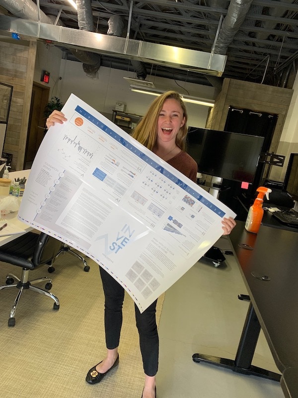 Ariana Goffe holding a large print design project.